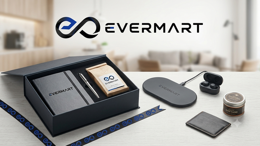 Premium Evermart corporate gift box featuring a black notebook, pen, coffee bag, wireless charger, earbuds, and leather cardholder on a light wooden table.